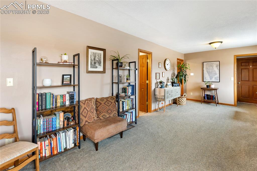 Image 15 of 42: The sitting room has a rich wood trim framing the room!