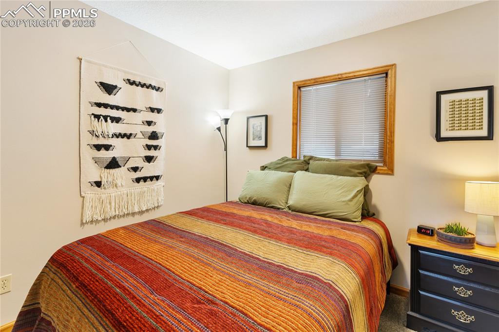 Image 17 of 42: The secondary bedroom features wood trim and a window!