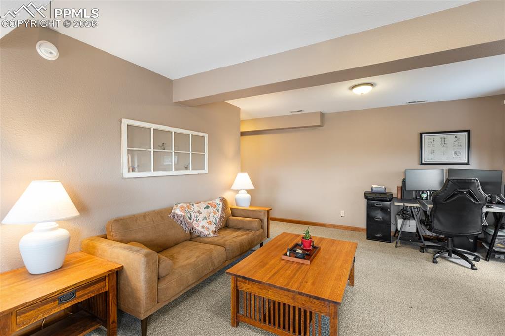 Image 21 of 42: The living room has rich wood trim and an architectural soffit detail!