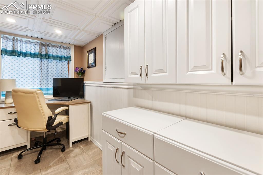 Image 22 of 42: The laundry area overlooks the office, providing convenient visibility and