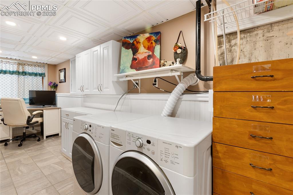 Image 23 of 42: The laundry area overlooks the office, with wainscoting and a coffered ceil