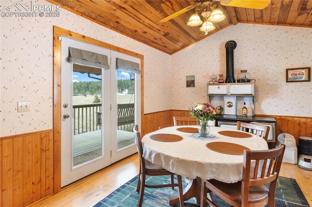 Image 6 of 42: The walkout dining space has a wainscoted wall and a vaulted ceiling, finis