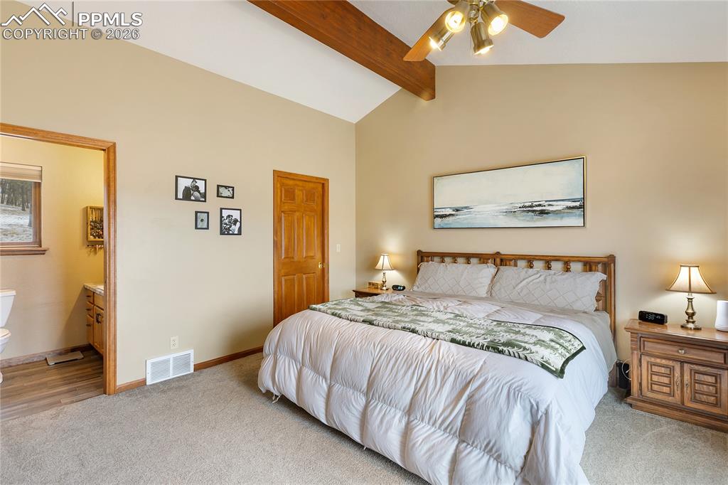Image 9 of 42: The main bedroom has a vaulted ceiling with a rich wooden beam, a ceiling f