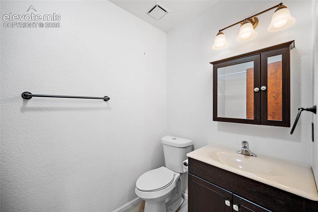 Image 14 of 26: Bathroom featuring a dark wood-finish vanity with an integrated sink, coord