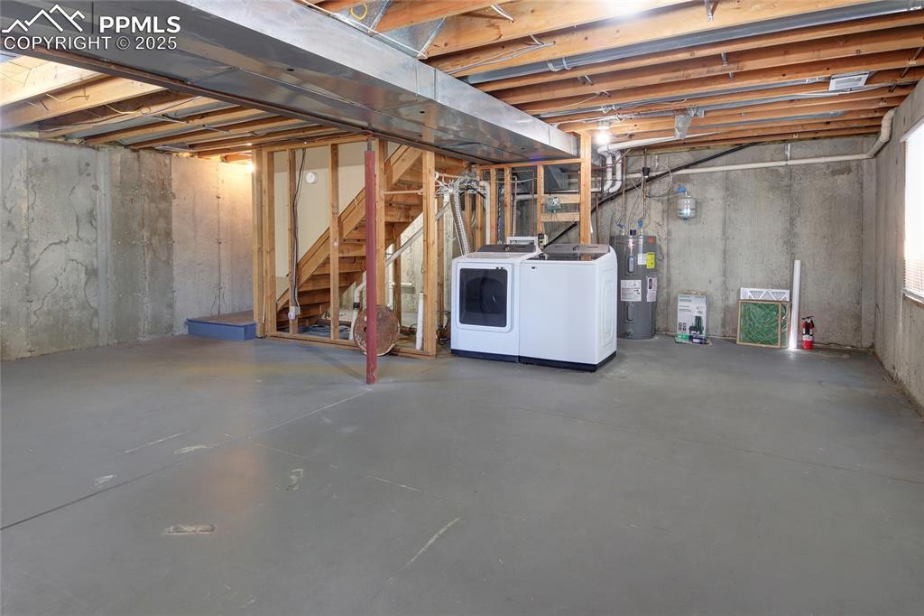 Image 26 of 33: Full Unfinished Basement featuring washing machine and clothes dryer