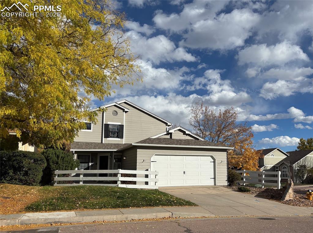 Image 33 of 33: View of front facade with a fenced front yard, driveway, roof with shingles