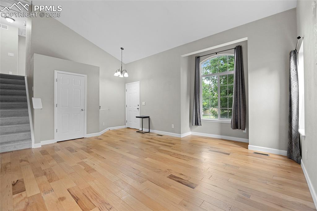 Image 12 of 50: Unfurnished dining area featuring stairway, light wood-type flooring, a cha