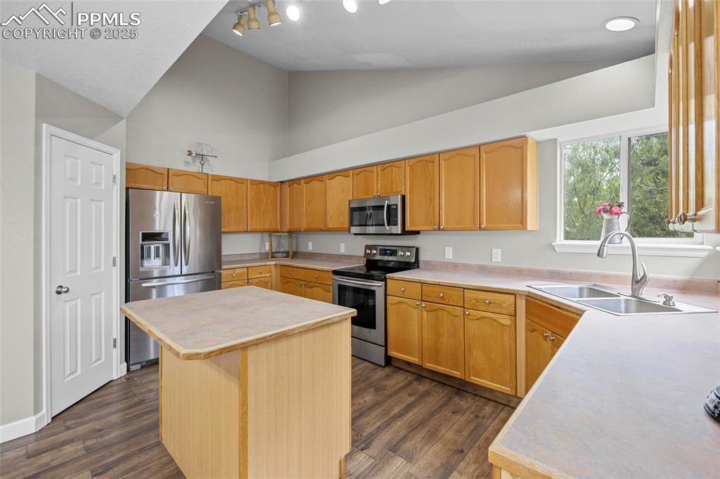 Image 14 of 50: Kitchen featuring light countertops, appliances with stainless steel finish