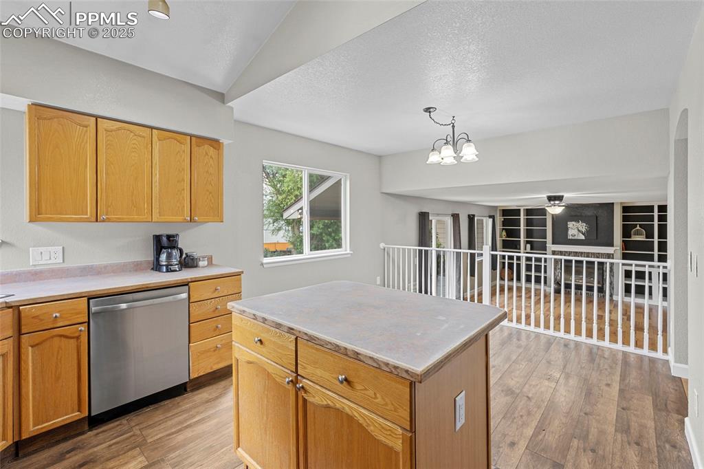 Image 16 of 50: Kitchen with light countertops, stainless steel dishwasher, light wood-type