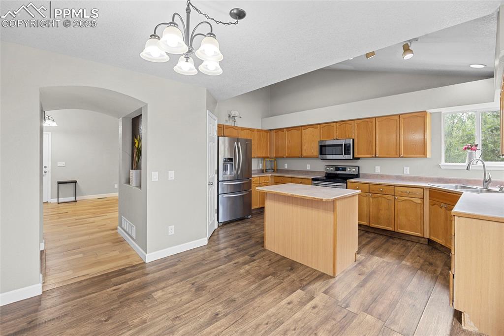Image 18 of 50: Kitchen featuring light countertops, pendant lighting, stainless steel appl
