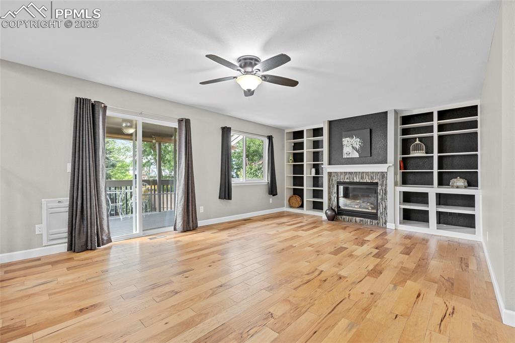 Image 19 of 50: Unfurnished living room featuring light wood finished floors, a glass cover