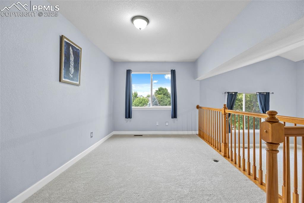 Image 26 of 50: Carpeted spare room with baseboards