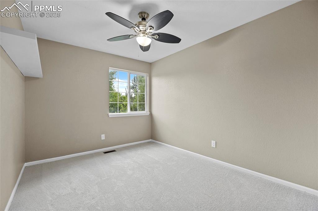 Image 32 of 50: Spare room featuring carpet flooring and a ceiling fan
