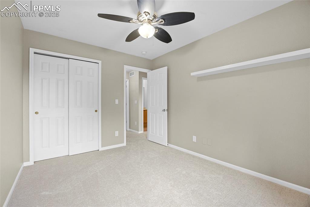 Image 33 of 50: Unfurnished bedroom featuring carpet flooring, a ceiling fan, and a closet