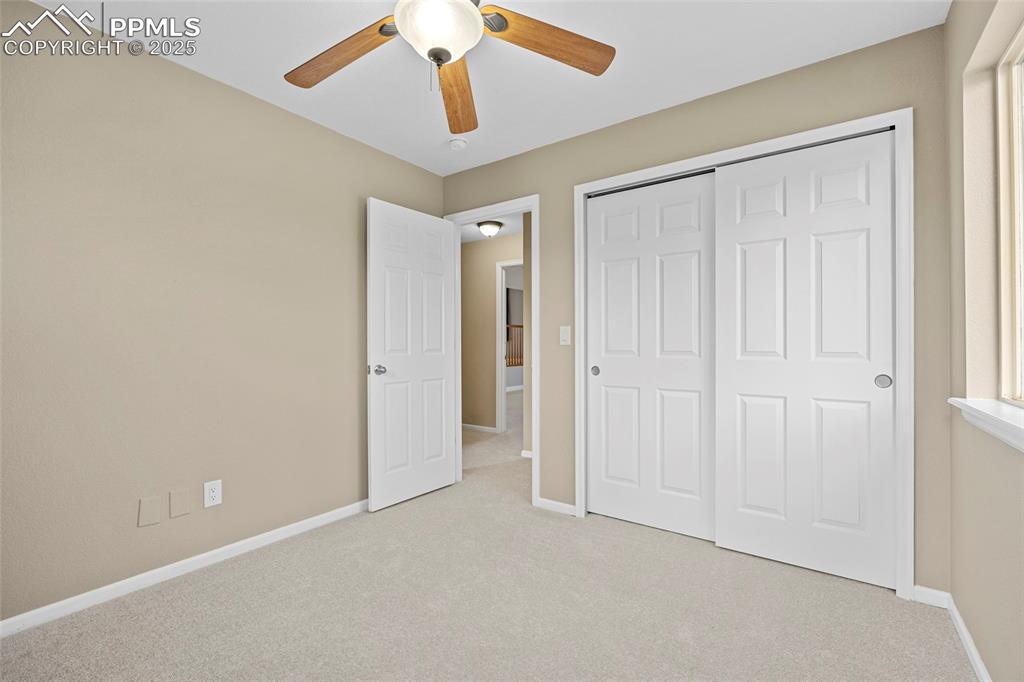 Image 36 of 50: Unfurnished bedroom with carpet flooring, a ceiling fan, and a closet
