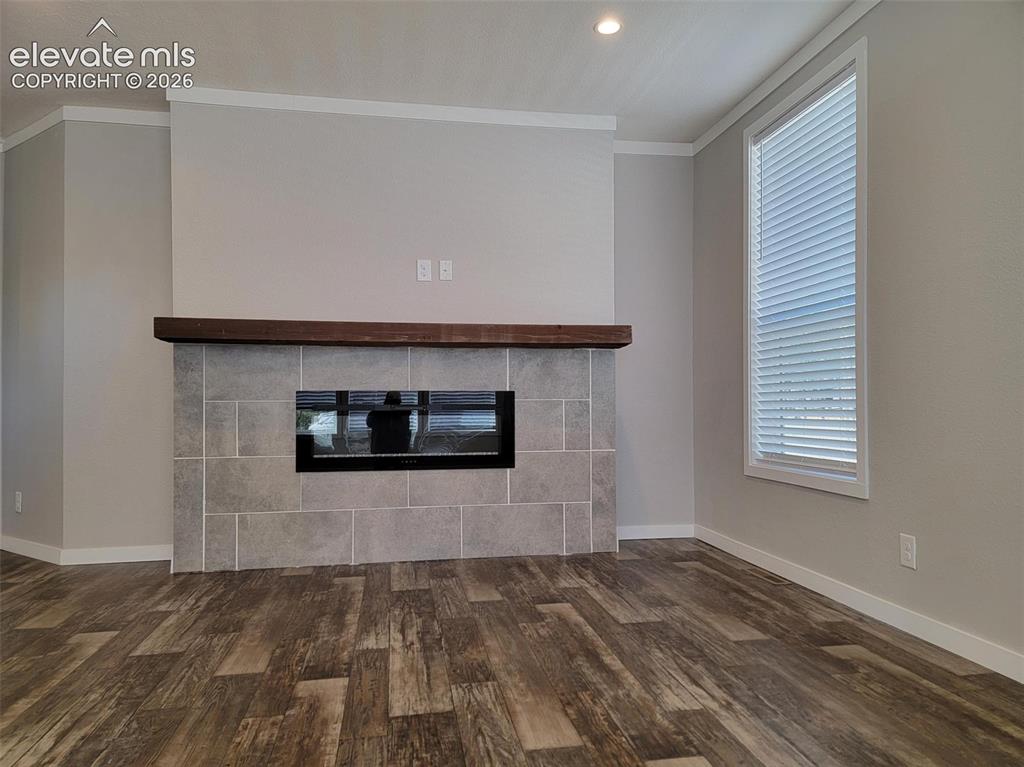 Image 27 of 41: Fireplace featuring a large-format tile surround, recessed electric insert,