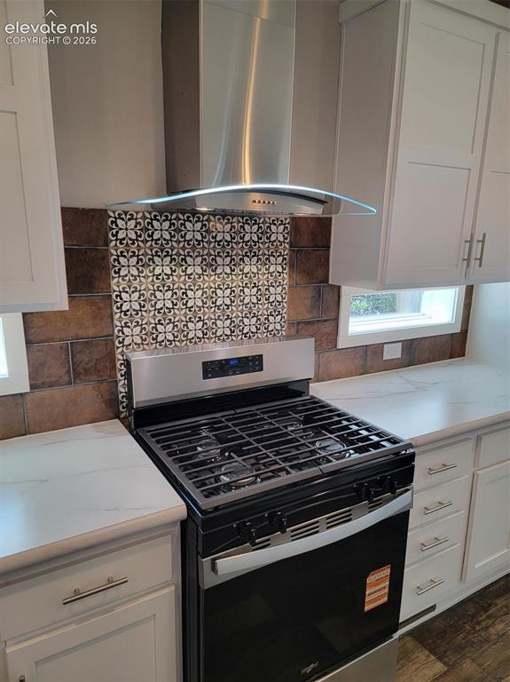 Image 29 of 41: Kitchen featuring shaker-style cabinetry, stainless steel gas range, glass-