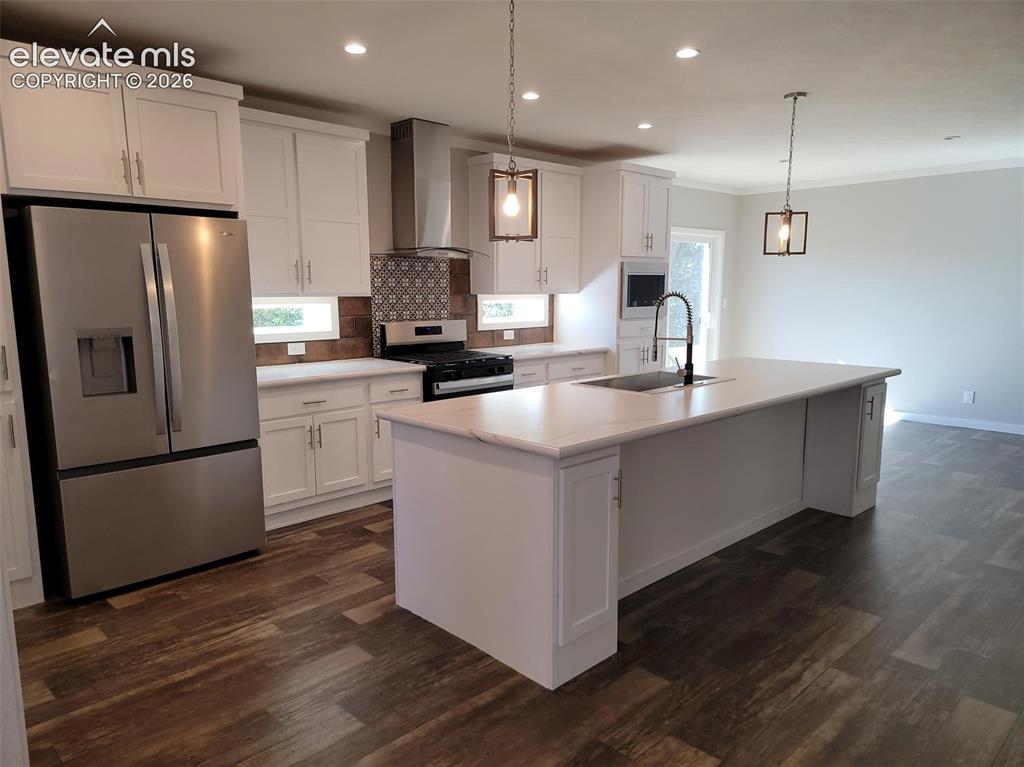 Image 3 of 41: Kitchen featuring white cabinetry, center island with sink, stainless steel