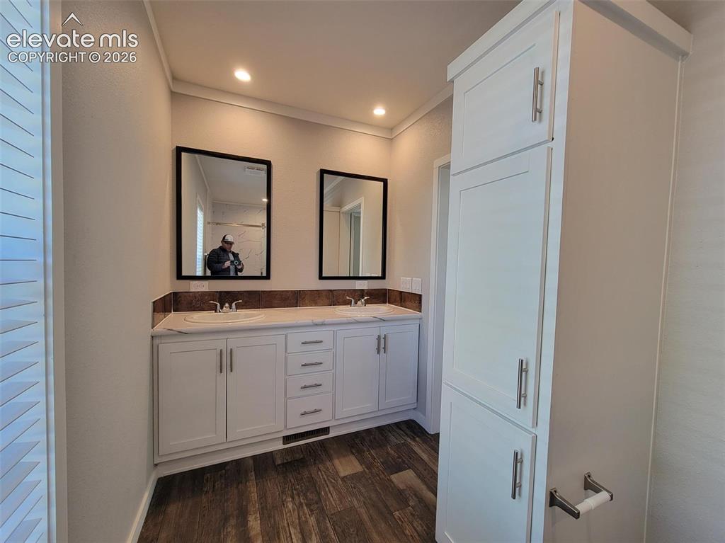 Image 33 of 41: Double vanity featuring white cabinetry, a countertop with dual drop-in sin