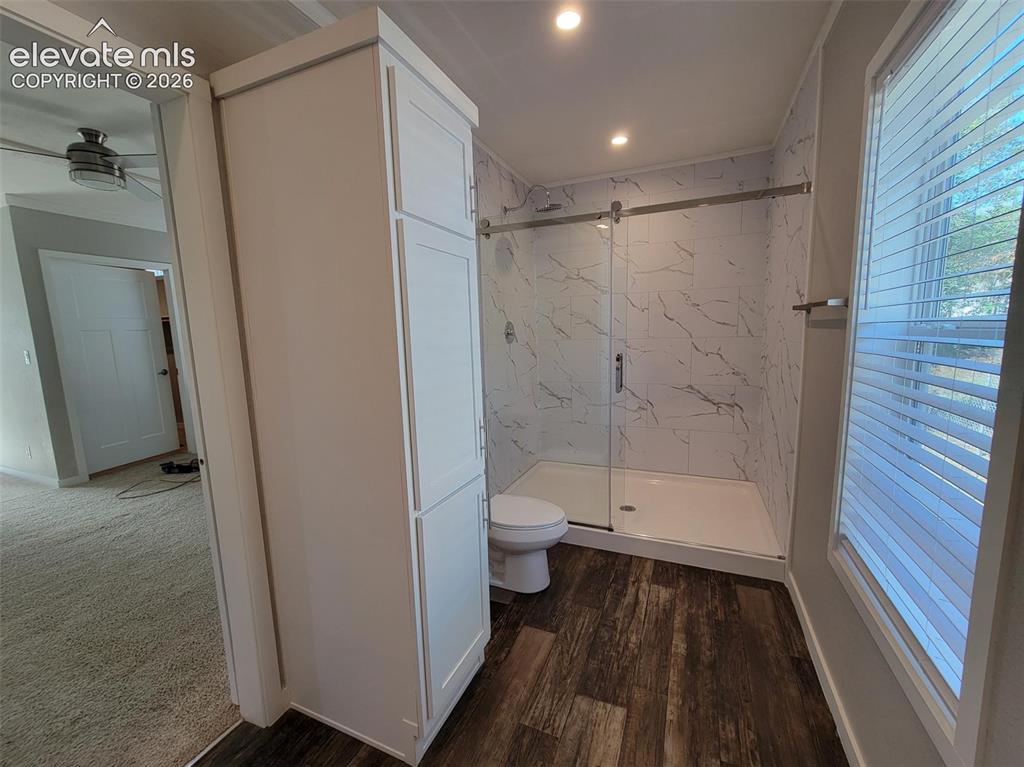 Image 35 of 41: Bathroom featuring a walk-in shower with glass sliding doors, stone-pattern
