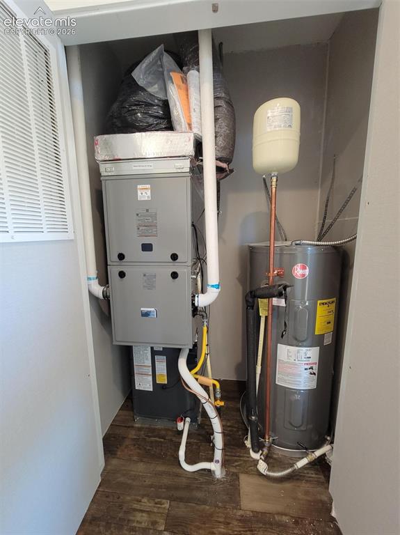 Image 38 of 41: Utility closet housing a forced-air furnace unit and a water heater tank wi