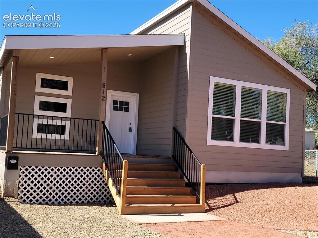 Image 39 of 41: Exterior facade featuring horizontal siding, a covered front porch with rec