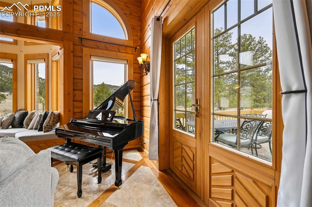 Image 17 of 50: Piano and back deck entry in living room 