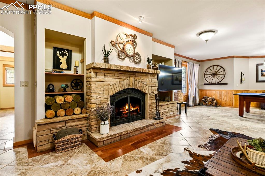 Image 32 of 50: Basement Living area with a fireplace and game table