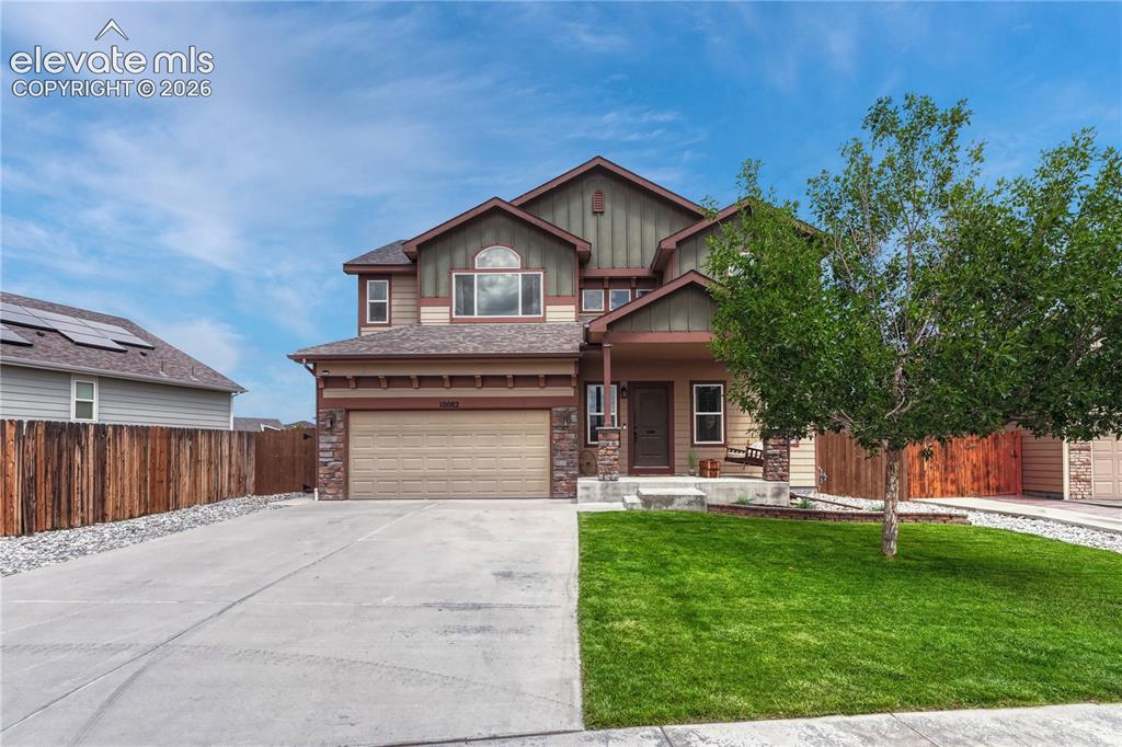 Caption: Two-story residence featuring a two-car garage, stone and siding exterior, a concrete driveway, and 