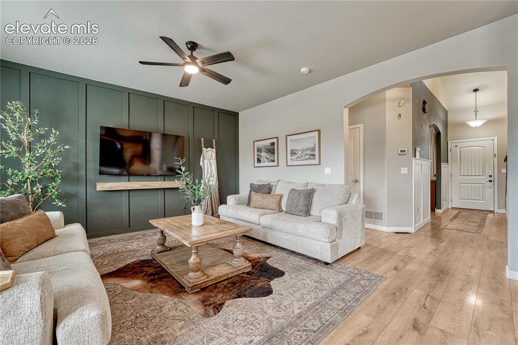 Image 3 of 50: Wood-finish flooring throughout, living area features a dark accent wall wi