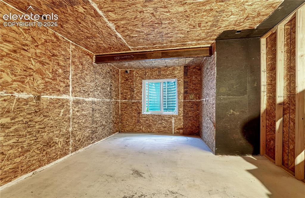 Image 33 of 50: Unfinished room with concrete flooring, oriented strand board walls and cei