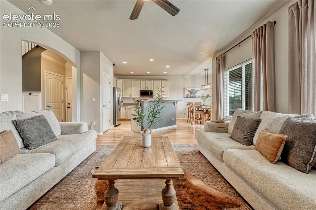 Image 4 of 50: Open-concept living space featuring wood-finish flooring, recessed lighting