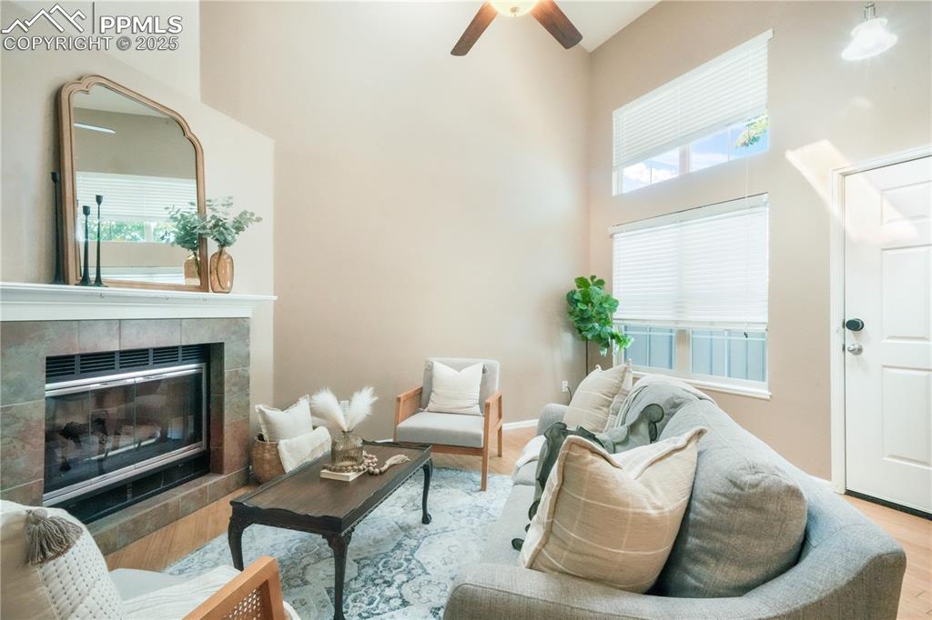 Image 12 of 47: Living area featuring a tiled fireplace, healthy amount of natural light, a