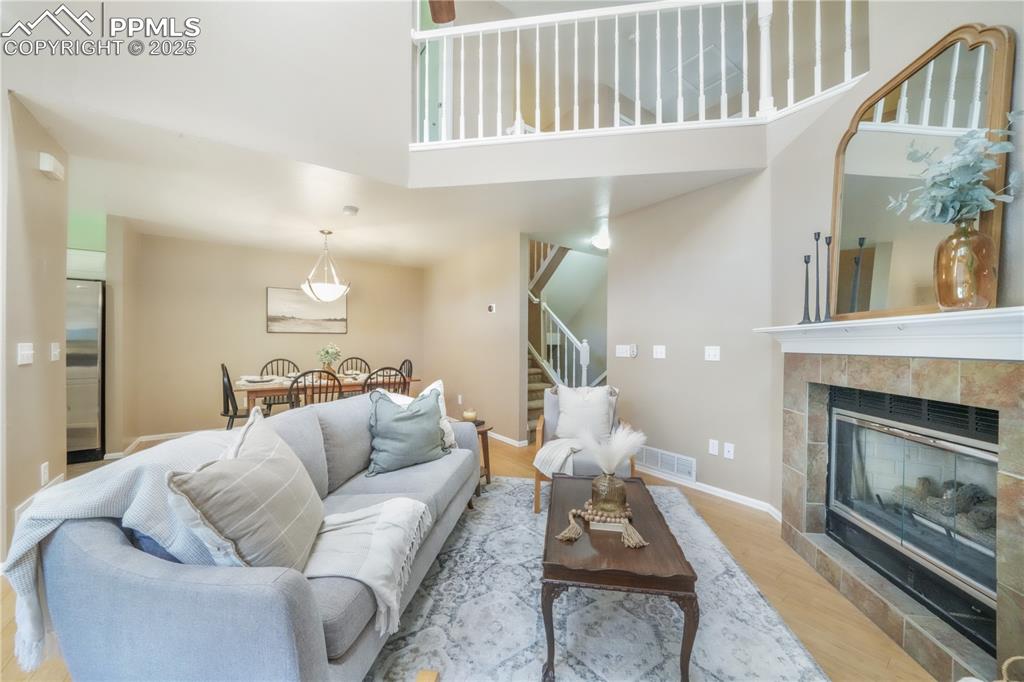 Image 13 of 47: Living area featuring wood finished floors, stairway, a fireplace, and a to