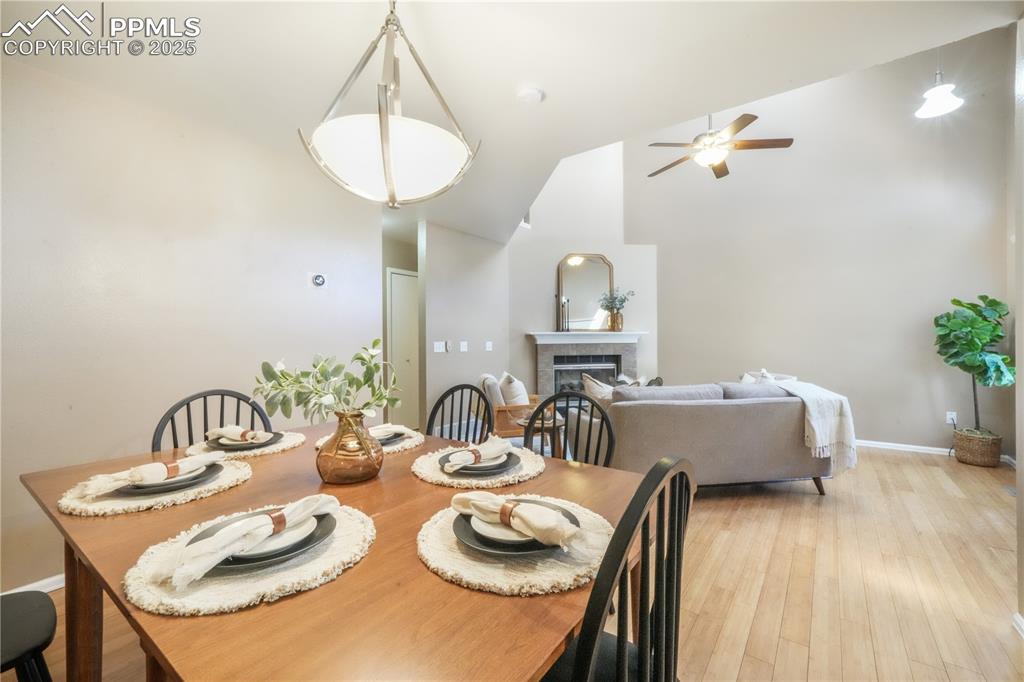 Image 16 of 47: Dining area featuring a fireplace, light wood-type flooring, ceiling fan, a