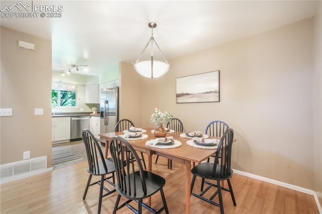 Image 17 of 47: Dining area with light wood-style flooring and baseboards