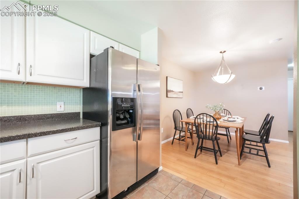 Image 21 of 47: Kitchen with white cabinets, stainless steel refrigerator with ice dispense