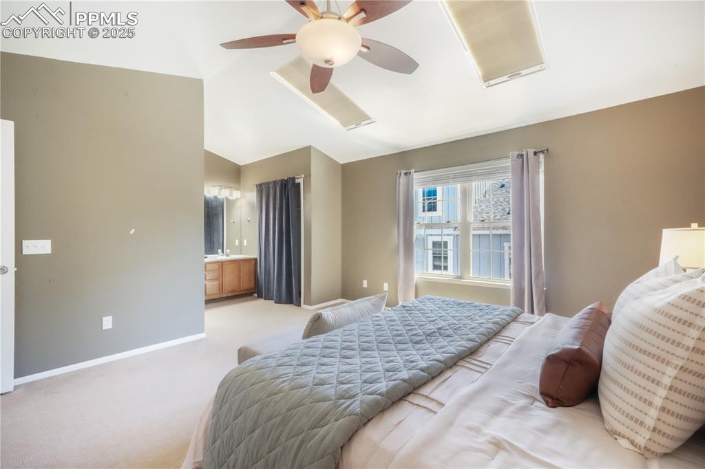Image 26 of 47: Bedroom featuring carpet floors, lofted ceiling, ceiling fan, and ensuite b