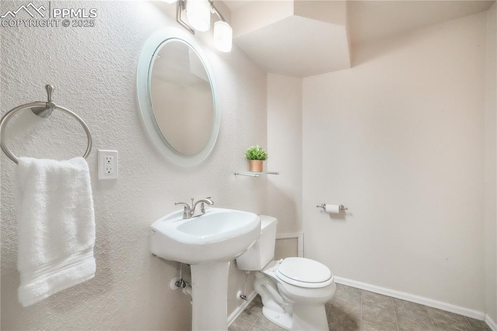 Image 37 of 47: Half bath featuring tile patterned floors and a textured wall