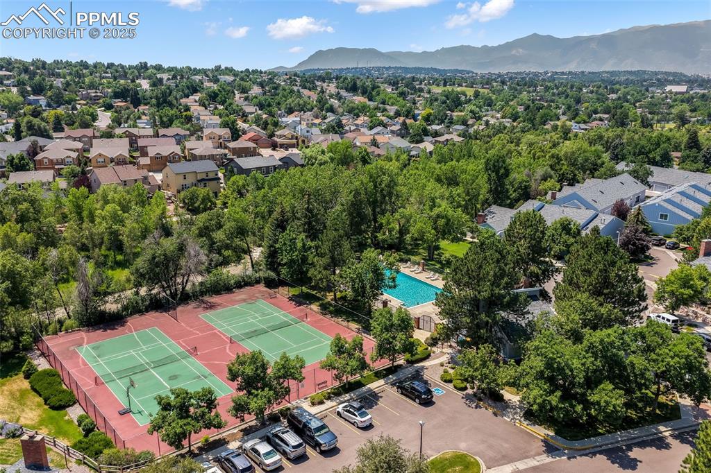 Image 43 of 47: Aerial perspective of suburban area featuring a mountain backdrop and a poo