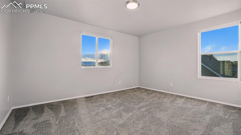 Image 34 of 50: Upper Level Bedroom #3 with neutral carpet.