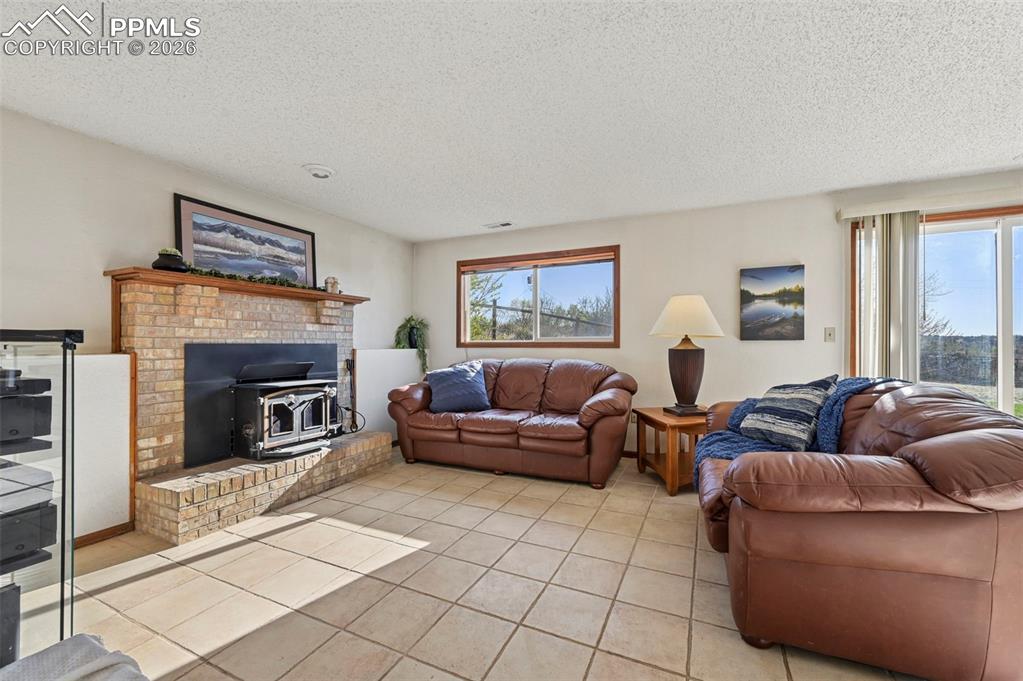 Image 23 of 45: Family room in basement  with wood fireplace