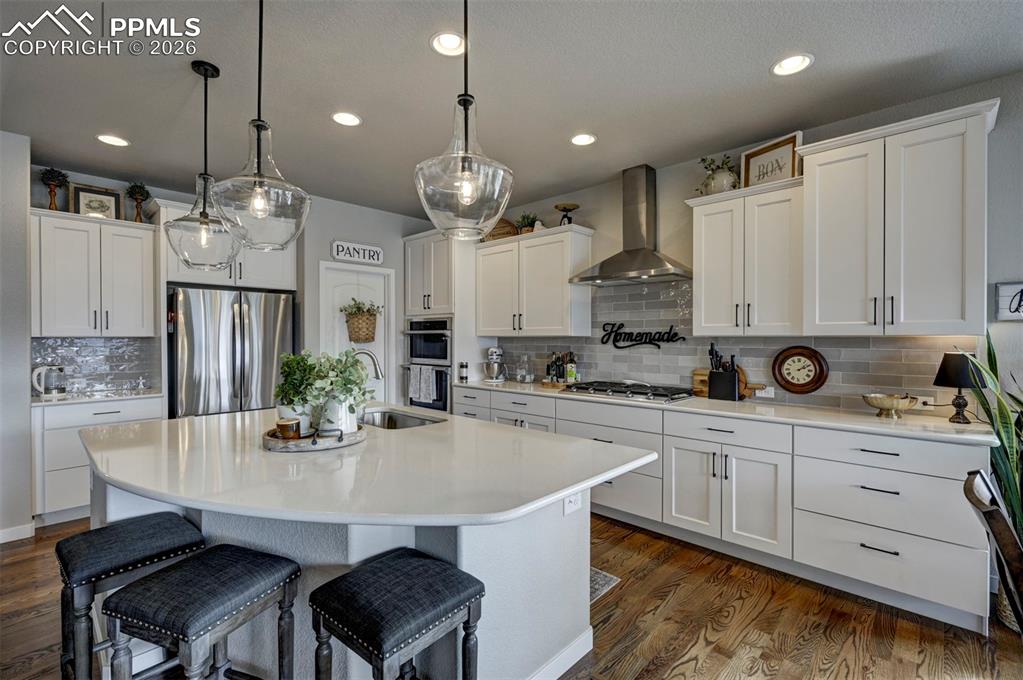 Image 16 of 41: Kitchen with a breakfast bar area, stainless steel appliances, an island wi