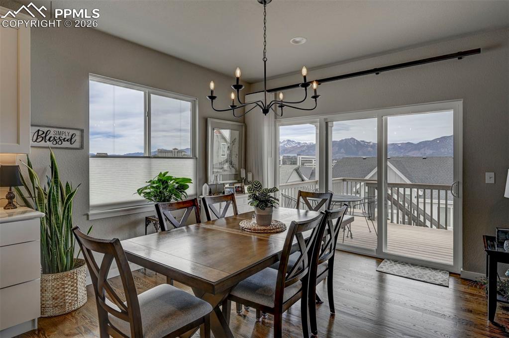 Image 17 of 41: Dining space featuring hanging lights, wood finished floors, and a mountain