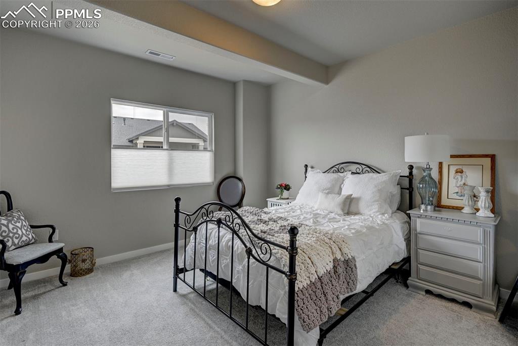 Image 27 of 41: Bedroom with light colored carpet and beam ceiling