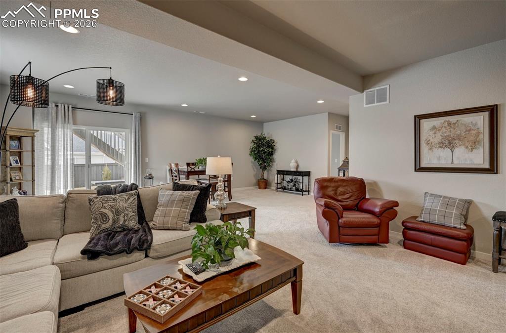 Image 30 of 41: Living room with light carpet and recessed lighting