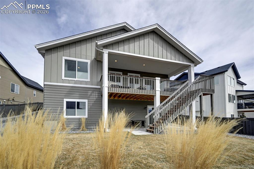 Image 36 of 41: Back of property with a patio area, board and batten siding, and a deck