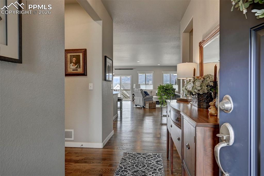 Image 5 of 41: Hall featuring a textured wall and dark wood-type flooring