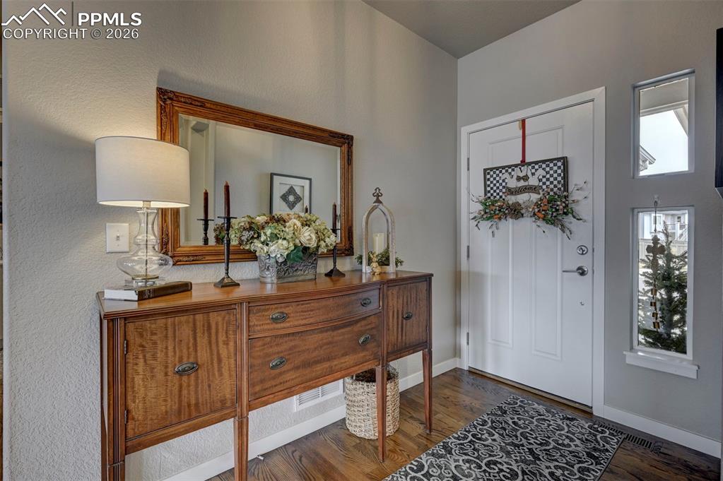 Image 6 of 41: Entryway featuring dark wood finished floors and baseboards
