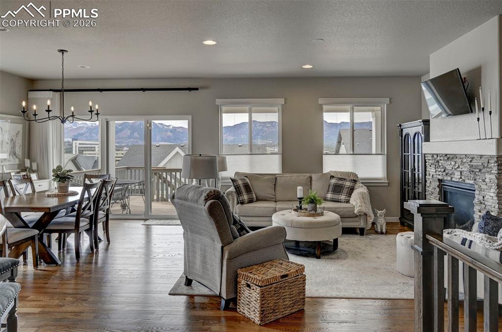 Image 8 of 41: Living area featuring a textured ceiling, a chandelier, a fireplace, health